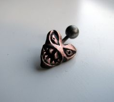 A belly ring featuring a pink heart with anger management issues. Sculpted in copper, oxidized to show details better and protected with jewelers lacquer. The heart is attached to one end of a 14 gauge curved barbell. I make the barbell about 1 cm long not counting the bend, if you want an other length let me know when ordering. I make this with a titanium bar or a 316L surgical steel bar. The titanium one is an externally threaded bar. The surgical steel one you can have either externally threa Earthy Belly Button Ring, Emo Belly Button Piercing, Gothic Belly Button Piercing, Punk Belly Button Piercing, Spiral Belly Button Rings, Belly Button Piercing Cute, Titanium Belly Ring, Bellybutton Piercings, Belly Piercing Ring