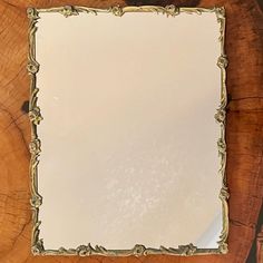 a mirror sitting on top of a wooden table next to a tree stump with leaves