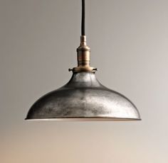 an industrial style light hanging from a ceiling fixture in a kitchen or dining room area