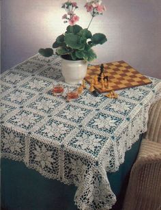 a potted plant sitting on top of a table next to a checkered cloth