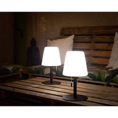 two lamps sitting on top of a wooden table