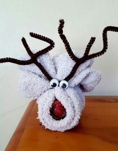 a stuffed reindeer head sitting on top of a wooden table