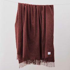 a brown blanket hanging on a clothes line with a white tag attached to the end