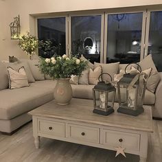 a living room filled with lots of furniture and flowers on top of a coffee table