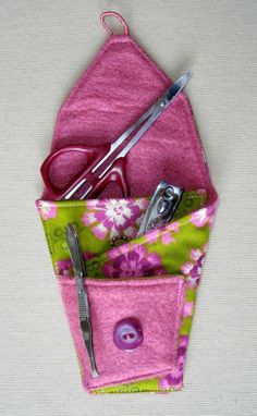 pink and green flowered pocket with scissors, sewing needle and eyeglasses in it