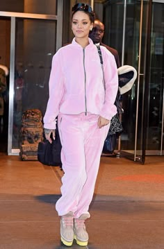 a woman in pink is walking down the street