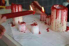 someone is lighting candles with blood on them