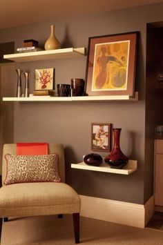 a living room filled with furniture and pictures on the wall above it's shelves