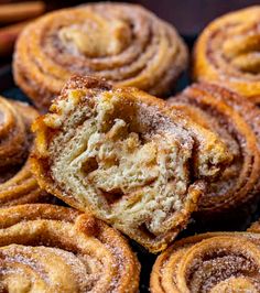 cinnamon rolls with powdered sugar on top sitting on a black plate next to other pastries