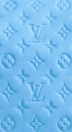 an image of a blue background with monogrammed letters and symbols on the fabric