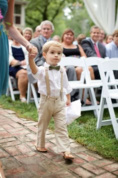 a little boy walking down the aisle at a wedding