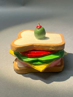 a green apple sitting on top of a sandwich