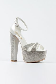 a woman's white high heeled sandal with silver glitters on the platform