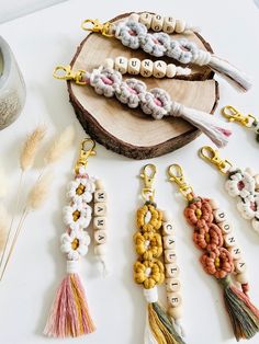 the beads and tassels are arranged on top of a wooden slice that is sitting next to each other