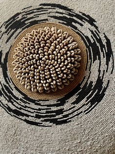 a round basket with black and white designs on it's sides, sitting in the middle of a floor