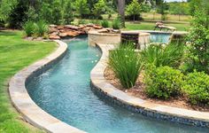 an outdoor swimming pool surrounded by lush green grass