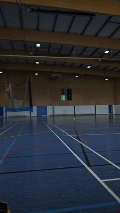 an empty gym with blue floors and white lines