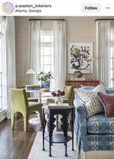 a living room filled with lots of furniture and decor on top of a hard wood floor