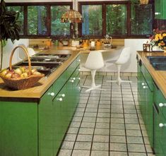 an image of a kitchen setting with green cabinets and white chairs in the center island