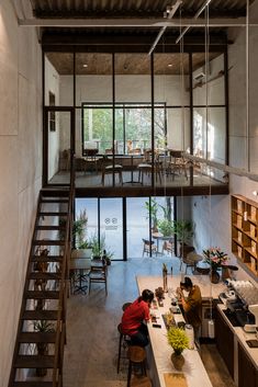 two people are sitting at a table in the middle of a room with stairs leading up to an open floor plan