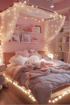 a bed with lights on the headboard and pillows in front of it, next to a book shelf