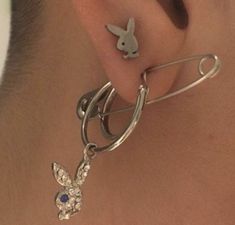 a person with ear piercings on their ears and behind the ear is a pin