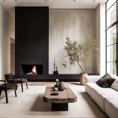 a living room with white couches and a fire place in the middle of it