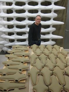 a man standing in front of some very large pieces of art made out of clay