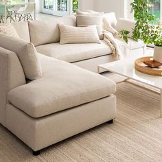 a living room filled with furniture and a white coffee table in front of a window