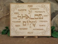 a wooden sign with hebrew writing on it