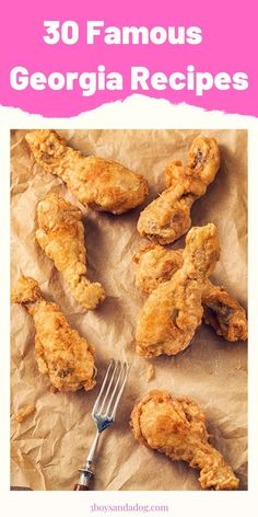 some fried chicken on top of a piece of parchment paper with a fork and knife