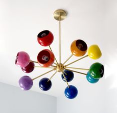 a multicolored chandelier hanging from the ceiling in a room with white walls