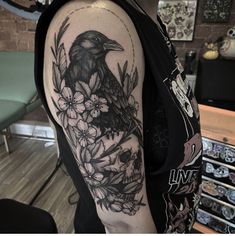 a black bird sitting on top of a flower filled arm