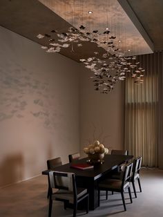 a dining room table with chairs and a large chandelier hanging from the ceiling