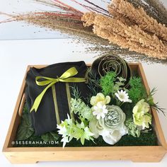 an arrangement of flowers in a wooden box