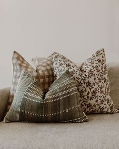 three decorative pillows on a couch in a living room