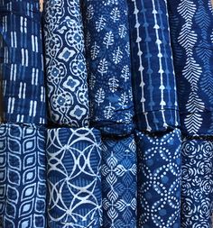 many different types of blue and white fabrics are stacked up on top of each other