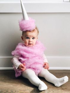 a baby wearing a pink costume with a white hat on it's head and legs