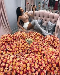 a woman laying on top of a bed covered in roses