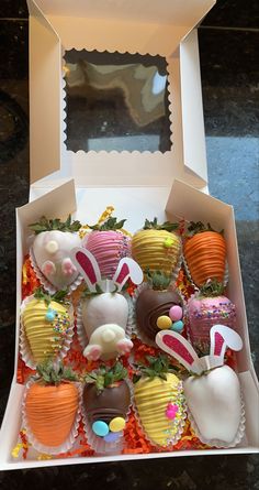 a box filled with lots of different types of chocolate covered strawberries and candy eggs