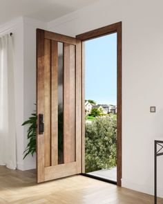 an open wooden door in the middle of a room with hardwood floors and white walls