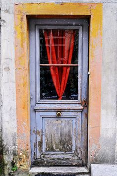 an old door with a red curtain on it