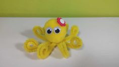 an octopus stuffed animal with a red flower on it's head sitting on a table