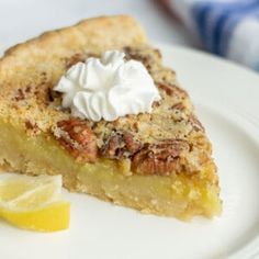 a piece of pie with whipped cream on top and lemon wedges next to it