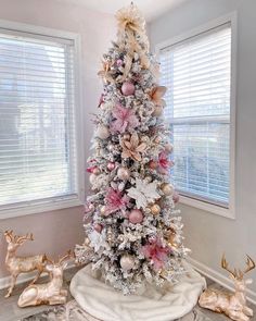 a white christmas tree with pink and gold ornaments