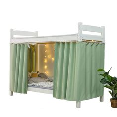 a white bunk bed with green curtains on the top and bottom, next to a potted plant