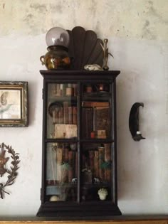 an old bookcase with many books on it in front of a wall mounted clock