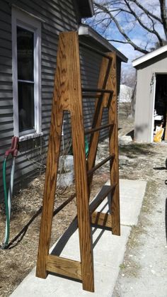 a wooden ladder sitting on top of a sidewalk