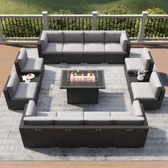 an outdoor living room with grey couches and a fire pit in the center area