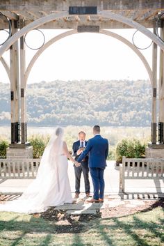 a bride and groom standing under an archway